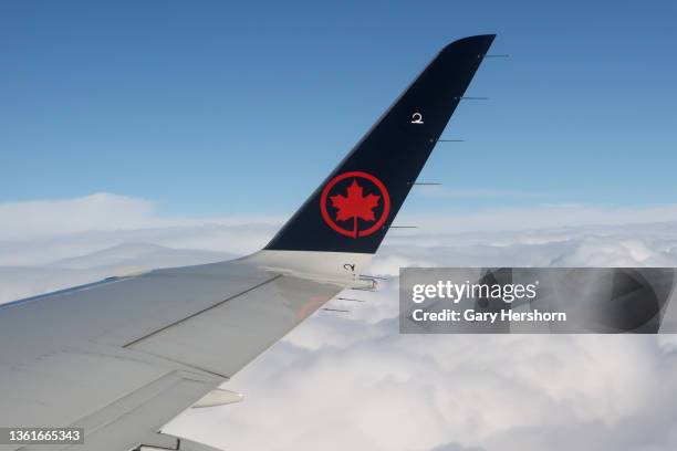 An Air Canada airplane flies above the clouds on approach to Pearson International Airport on December 27 in Toronto, Canada.