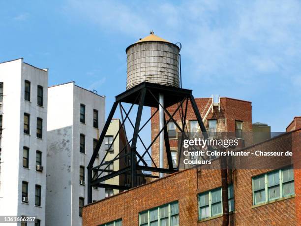 ancient water tank on a roof and building facades in manhattan - hunter, new york stock-fotos und bilder