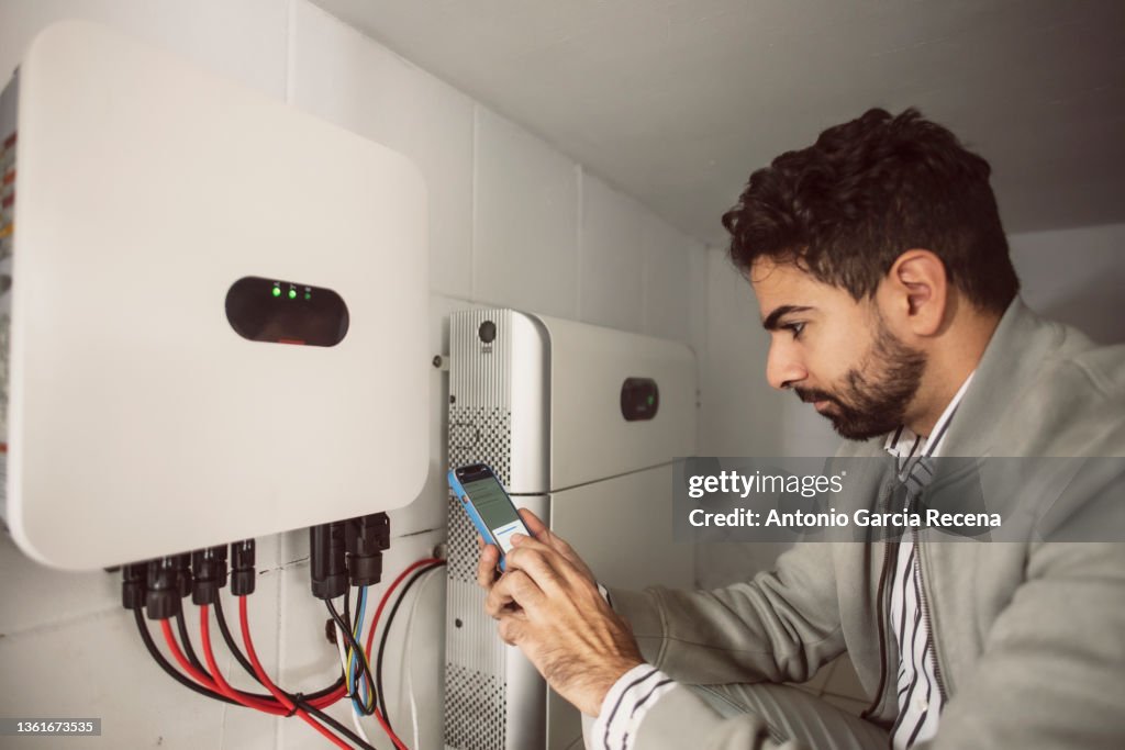 Commercial agent and technical electrician synchronize the converter and the storage battery of the solar panels through the mobile phone application
