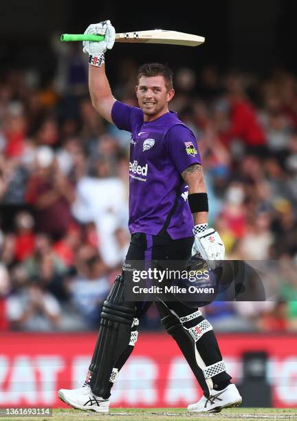 Ben McDermott of the Hurricanes raises his bat after scoring a century during the Men's Big Bash League match between the Melbourne Renegades and the...
