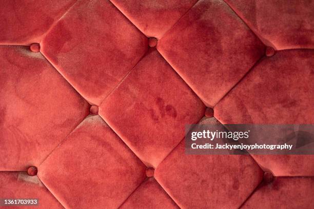 full frame shot of red velvet sofa - cushion stock-fotos und bilder