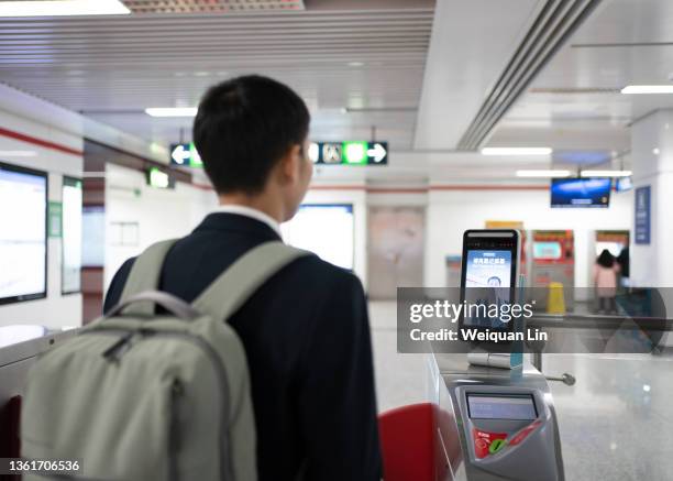 asian men use facial recognition to pay subway fares - biometrics stockfoto's en -beelden