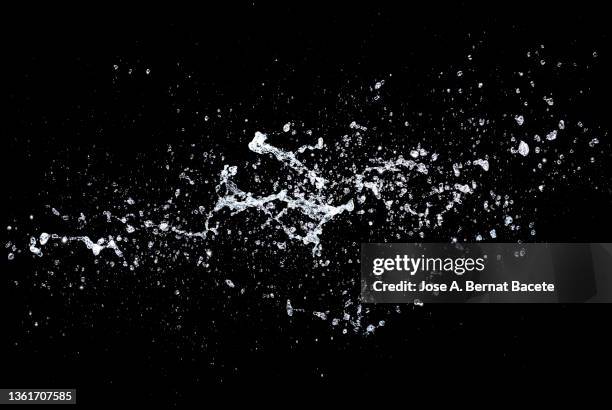 drops and splashes of water floating in the air on a black background. - horizontal falls stock pictures, royalty-free photos & images