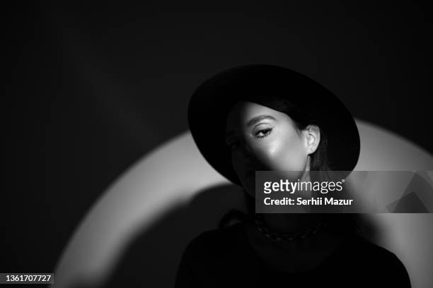 young beautiful woman portrait in round hat with shadow on her face - stock photo - girl band - fotografias e filmes do acervo