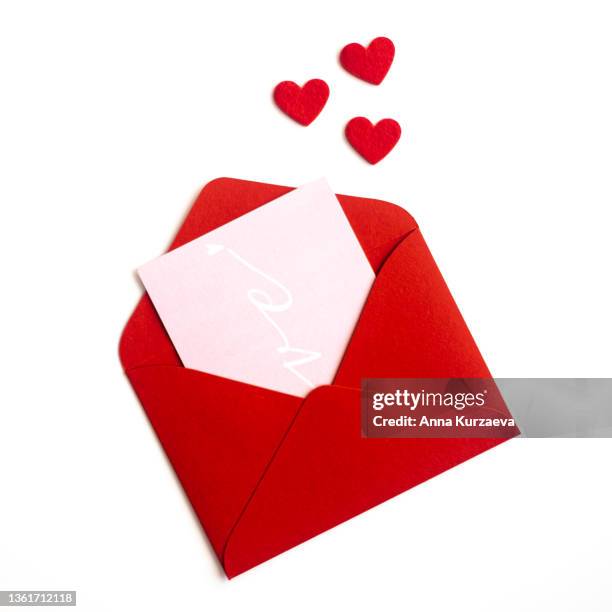 close-up of red envelope with love postcard isolated on white background, top view. valentine's day card. - auguri di buon anniversario foto e immagini stock