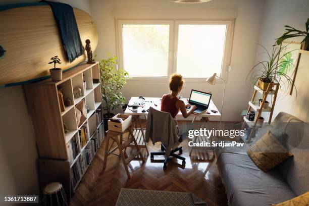 dedicated female programmer, at her modern home office, working on open-source hardware and software software platform, on the laptop - web programmer stock pictures, royalty-free photos & images