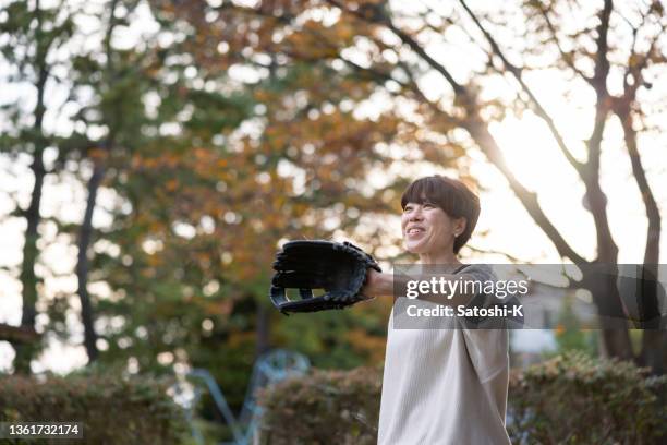 woman playing catch in public park - playing catch stock pictures, royalty-free photos & images