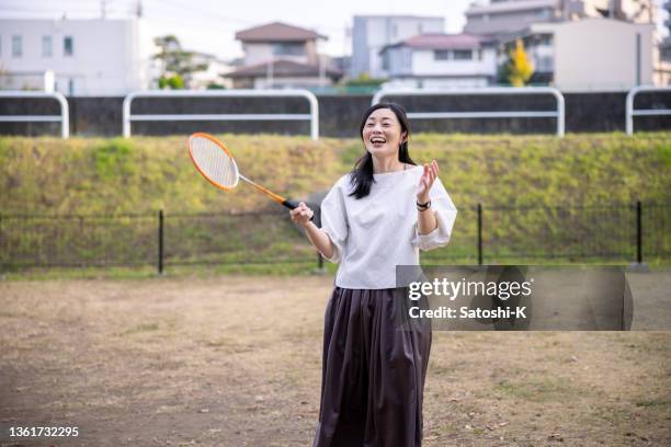 woman playing badminton in public park - womens badminton bildbanksfoton och bilder