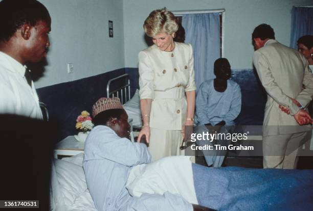 British Royals Diana, Princess of Wales , wearing a Catherine Walker suit, and her husband, Charles, Prince of Wales, with an patient during a visit...