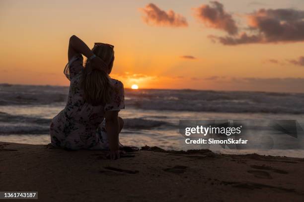 frau genießt am strand bei sonnenuntergang, sardinien, italien. - romantischer sonnenuntergang stock-fotos und bilder