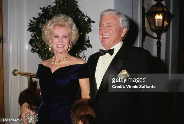 Hungarian-American actress and socialite Eva Gabor , wearing a blue velvet off-shoulder dress, and American television host Merv Griffin , wearing a...