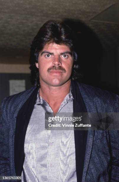 American football player Mark Gastineau wearing a grey jacket over a silver shirt, circa 1985. Gastineau is a defensive end for the New York Jets.