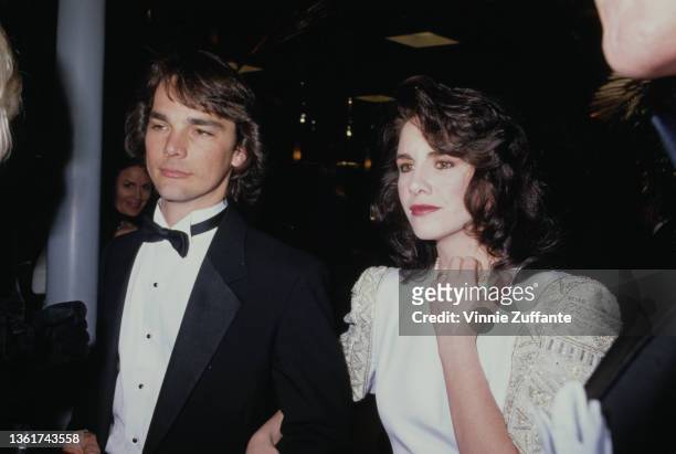 American actor Bo Brinkman and his wife, American actress Melissa Gilbert, wearing a white outfit with gold detail on the shoulders, attend the...