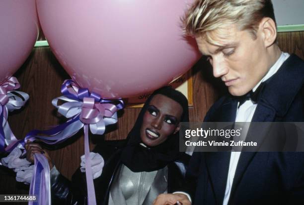 Jamaican-American fashion model, singer and actress Grace Jones, wearing a black leather jacket and a headscarf, and her partner, Swedish actor Dolph...