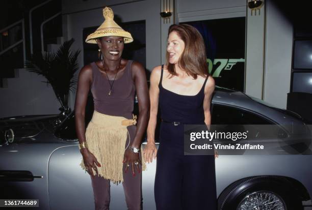 Jamaican-American fashion model, singer and actress Grace Jones, wearing a gold-fringed outfit with an Asian-style conical hat, and American actress...