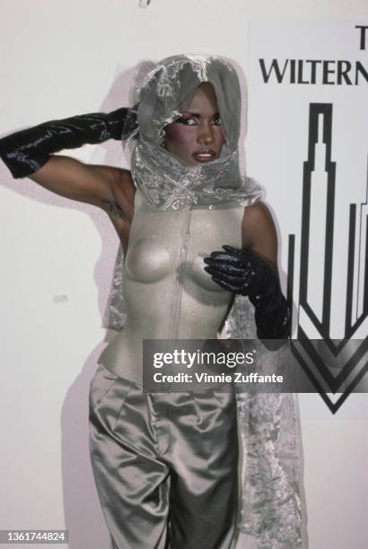 Jamaican-American fashion model, singer and actress Grace Jones, wearing a silver outfit with black evening gloves, attends the 4th Annual American...