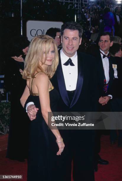 American actress Kelly Preston , wearing a black dress with gold trimming, and her husband, American actor John Travolta, wearing a black tuxedo and...