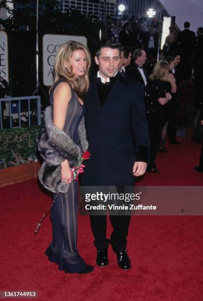 American wardrobe assistant Jennifer Mullins, wearing a striped black dress with a grey fur wrap, and American actor Matt LeBlanc, wearing a black...