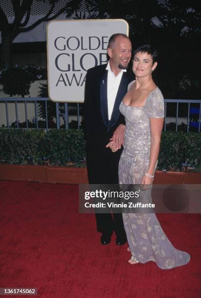 American actor Bruce Willis and his wife, American actress Demi Moore, wearing a grey evening gown with silver leaf motifs, attend the 54th Golden...