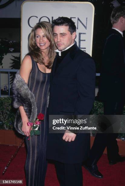 American wardrobe assistant Jennifer Mullins, wearing a striped black dress with a grey fur wrap, and American actor Matt LeBlanc, wearing a black...