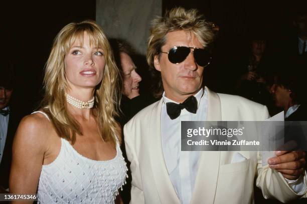 American model Kelly Emberg, wearing a white scooped neck outfit with pearl choker, and her partner, British singer and songwriter Rod Stewart,...