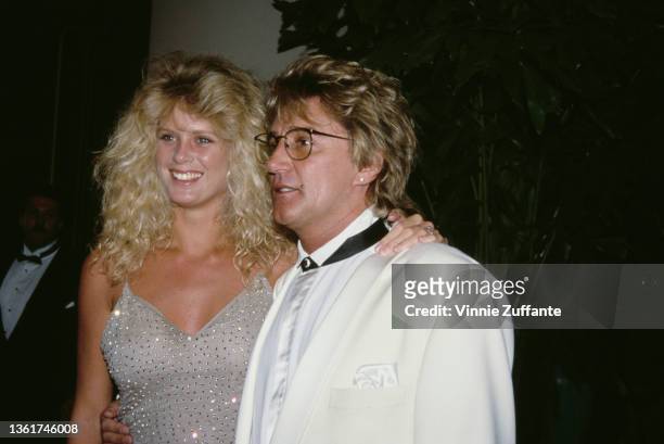 New Zealand model Rachel Hunter, wearing a sparkling outfit, and her husband, British singer and songwriter Rod Stewart, wearing a white tuxedo,...