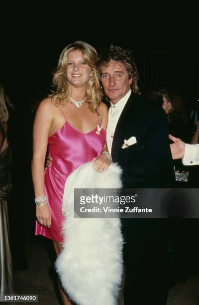 New Zealand model Rachel Hunter, wearing a pink dress, and her husband, British singer and songwriter Rod Stewart attend the 10th Carousel of Hope...