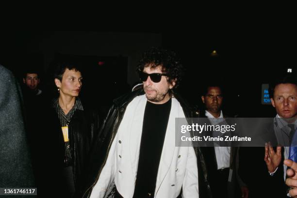 American singer-songwriter Bob Dylan wearing a white jacket over a black t-shirt with sunglasses, attends an event in Los Angeles, California, circa...