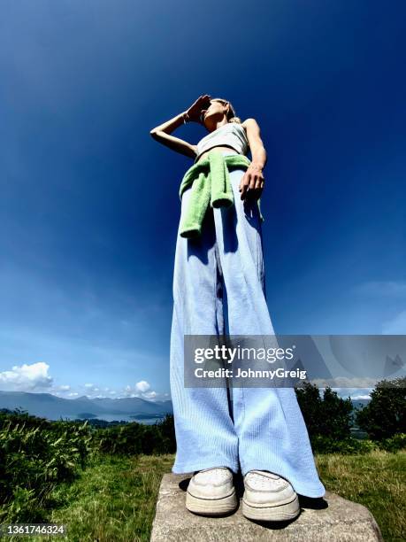 vue super grand angle d’une adolescente regardant vers l’horizon - pantalon à pattes d'éléphant photos et images de collection