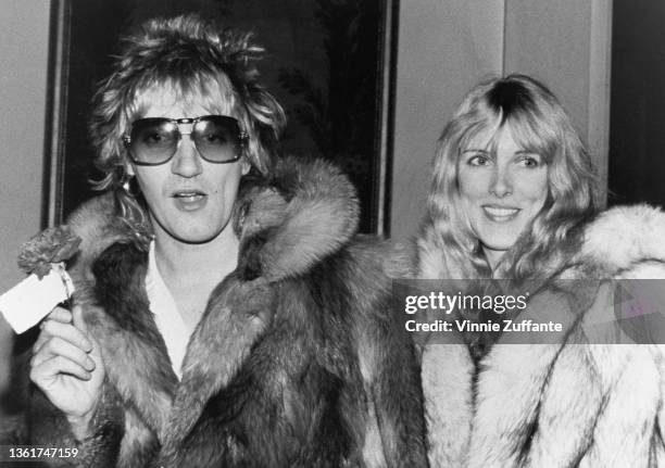 British singer and songwriter Rod Stewart and his partner, American actress Alana Hamilton, both wearing fur coats, attend Rod's 34th birthday...