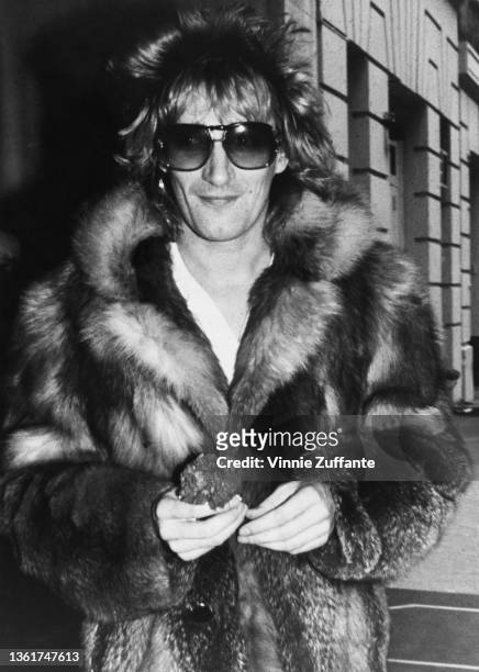 British singer and songwriter Rod Stewart wearing a fur coat and sunglasses attend his 34th birthday celebrations at the Carlyle Hotel in New York...