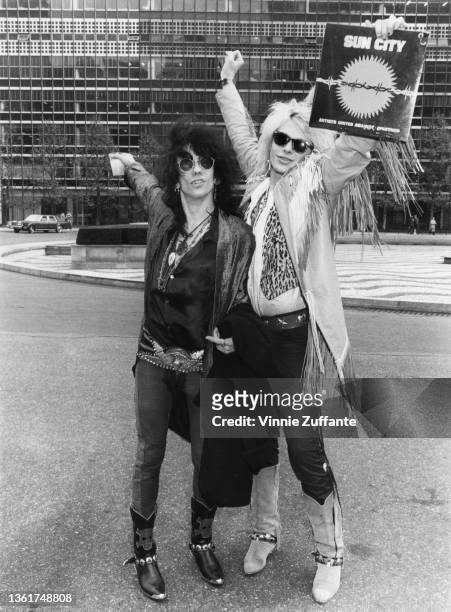 American singer and guitarist Stiv Bators and Finnish singer and guitarist Michael Monroe, holding the 'Sun City' album on which both himself and...