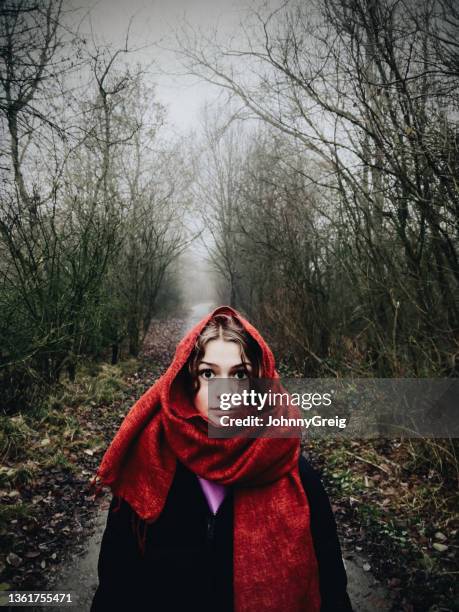 teenage girl with red scarf walking down path in misty wood - girl scarf bildbanksfoton och bilder