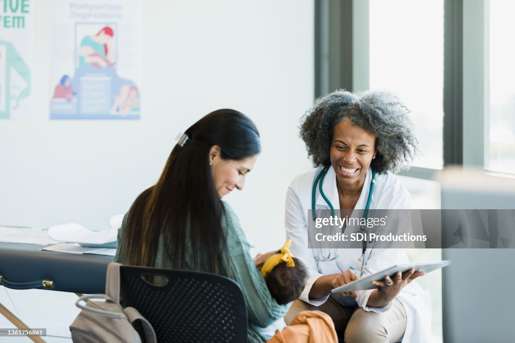 Mom and doctor smile when baby makes noise