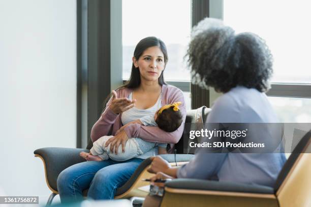 la mujer gesticula mientras comparte las luchas con el terapeuta - baby depression fotografías e imágenes de stock