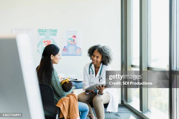 female doctor and patient discuss treatment options - healthcare tablet image focus technique stock pictures, royalty-free photos & images