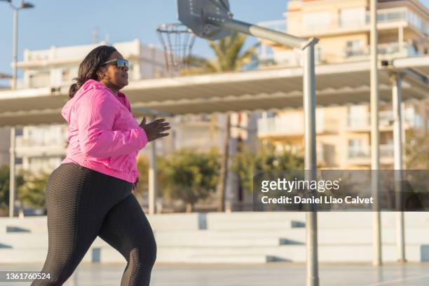 african american sportswoman jogging on city street - morbidly obese woman 個照片及圖片檔