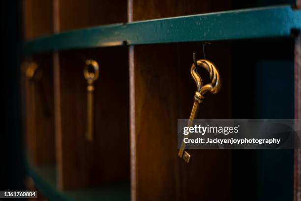 a singular gold key suspended in the air - mystery stockfoto's en -beelden