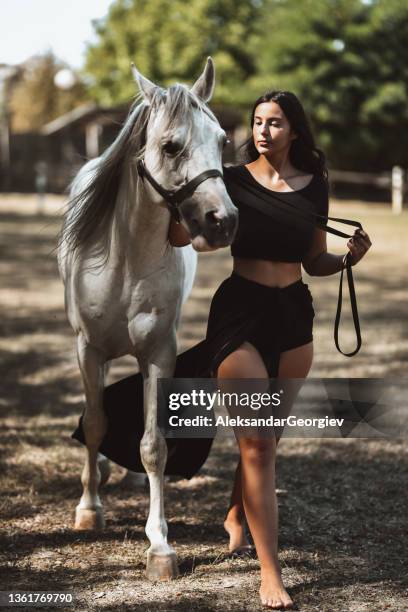 barefoot gypsy female leading her favorite horse on ranch - rein stock pictures, royalty-free photos & images