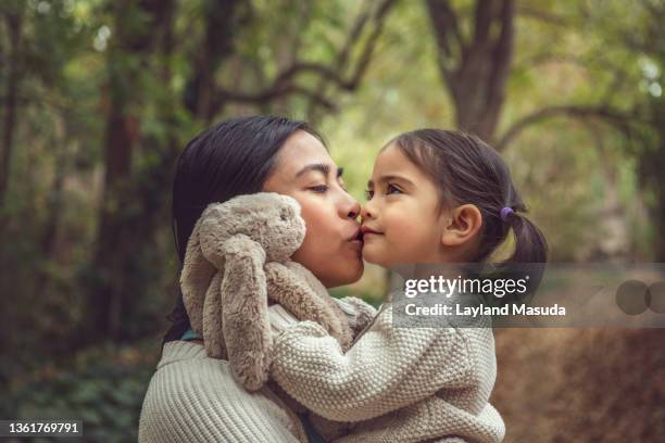 mother toddler daughter kiss in the woods - filipino girl fotografías e imágenes de stock