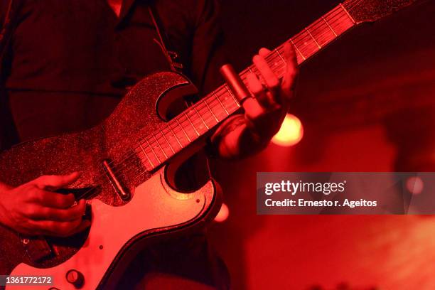 detail of man playing guitar on stage with a silde - rockmuziek stockfoto's en -beelden