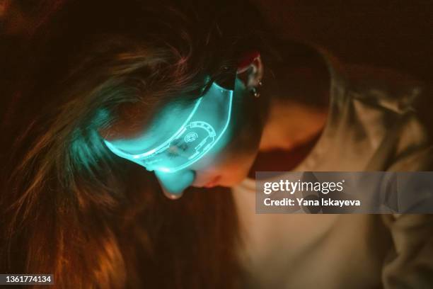 young woman scientist is wearing futuristic vr glasses is looking down at night - stem stock pictures, royalty-free photos & images