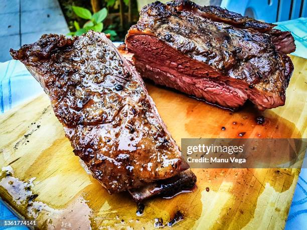 close-up of argentine grilled ribs (asado argentino or costillar) on a wooden board - argentina steak fotografías e imágenes de stock
