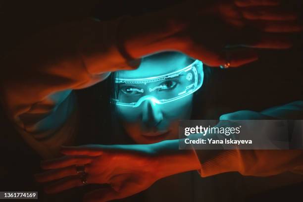 young woman in futuristic vr glasses is looking through her arms - tomorrow stock-fotos und bilder