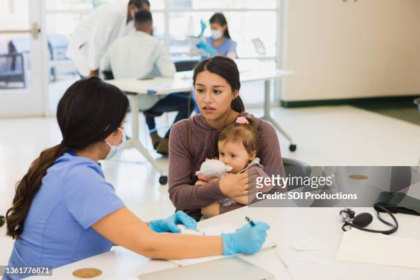 while talking to nurse, baby is scared and mother worries - worry free stock pictures, royalty-free photos & images