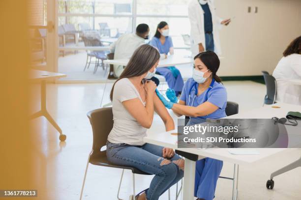 woman receives covid vaccine at free clinic - gratis stock pictures, royalty-free photos & images