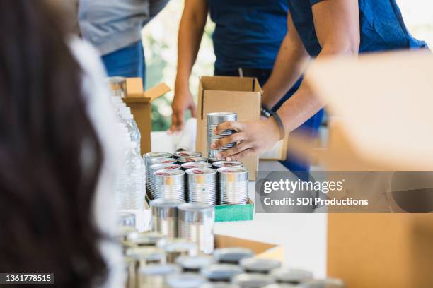 close-up view unrecognizable people sorting donated food - recolha-de-alimentos imagens e fotografias de stock