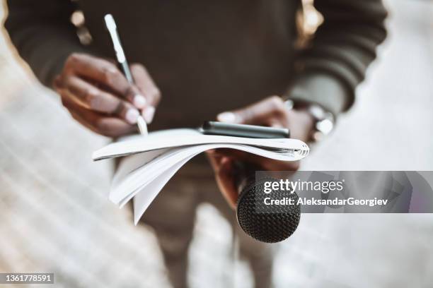 african male journalist writing down questions and preparing before press conference starts - joy press conference stockfoto's en -beelden