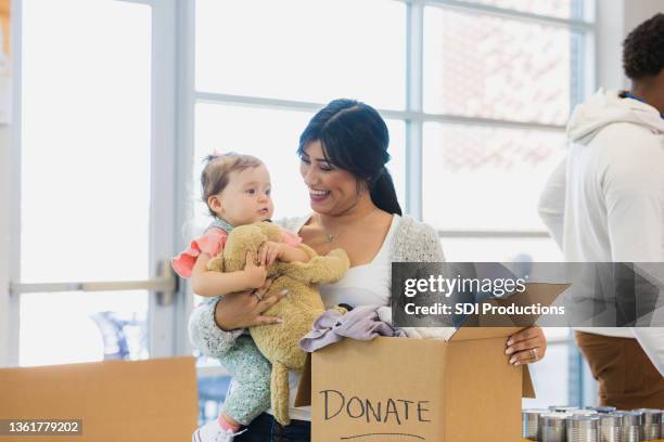 woman donates box of clothes during charity drive - clothing donation stock pictures, royalty-free photos & images