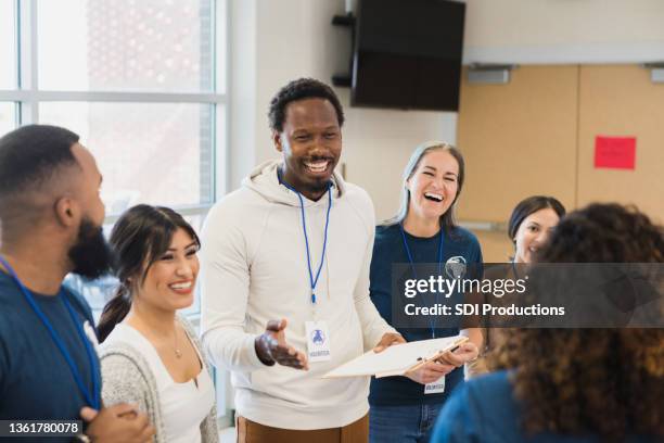 diverse group of adults enjoys volunteering together - volunteers stock pictures, royalty-free photos & images